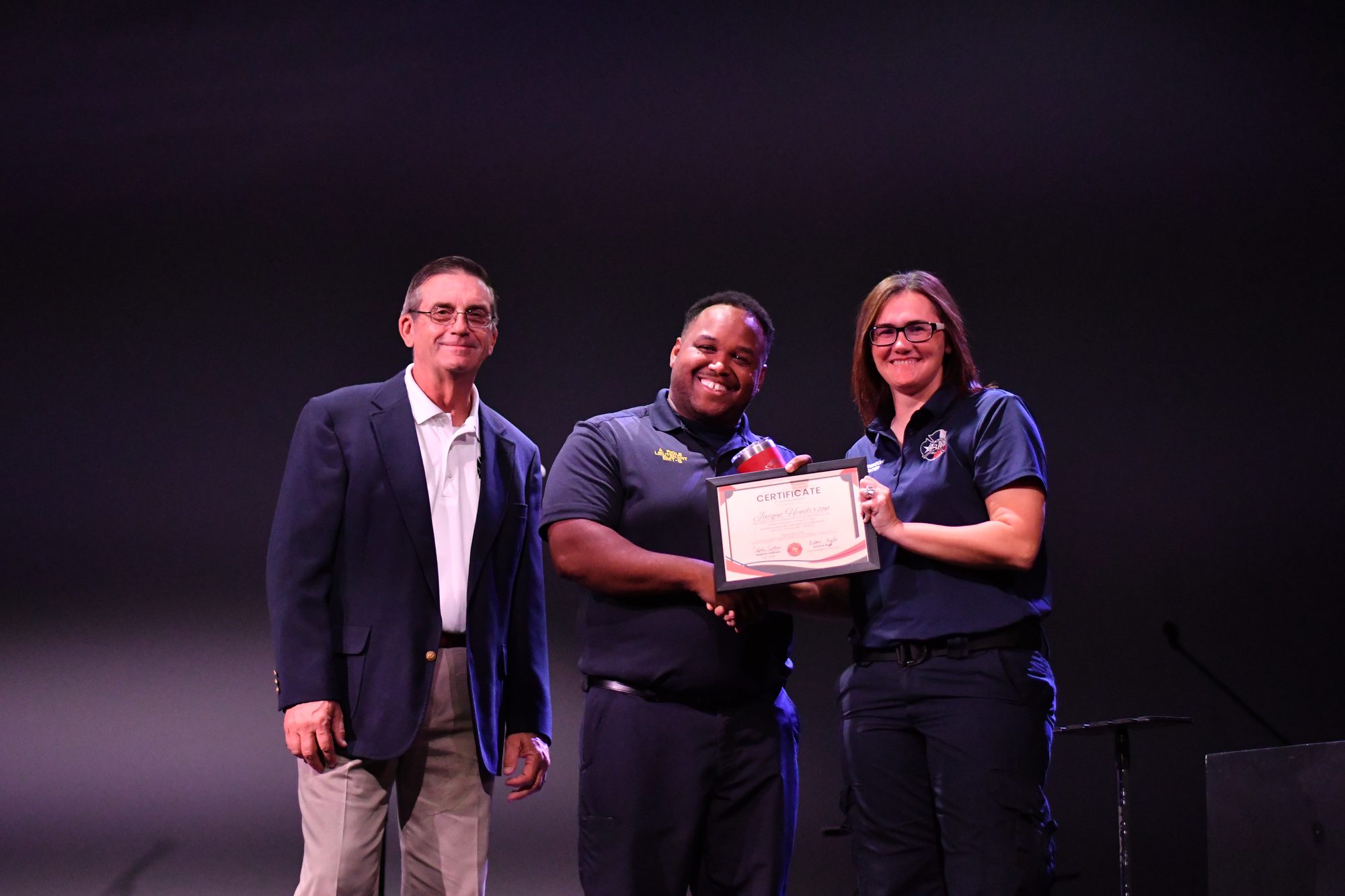 A member receives a certificate on stage