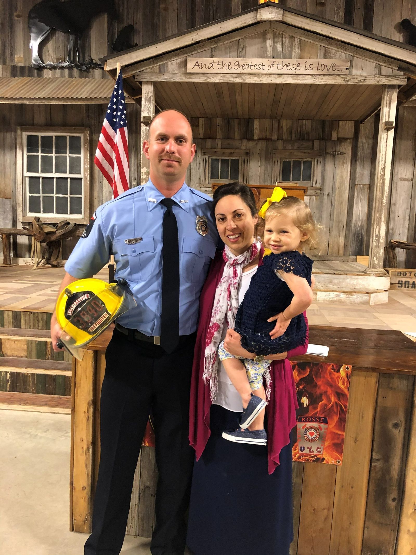 A firefighter in dress uniform with family
