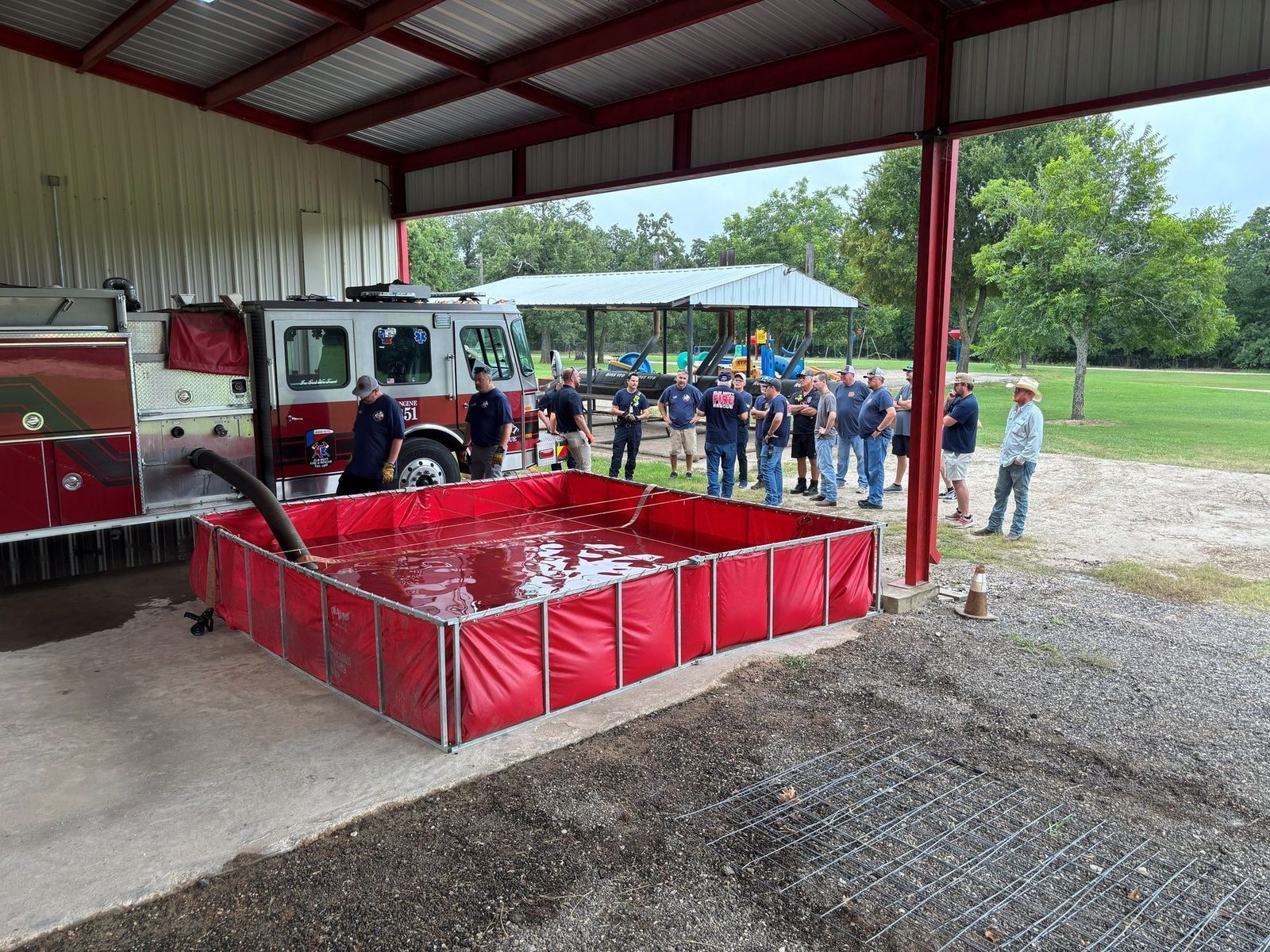 Members run a rural water drafting drill from a portable pond