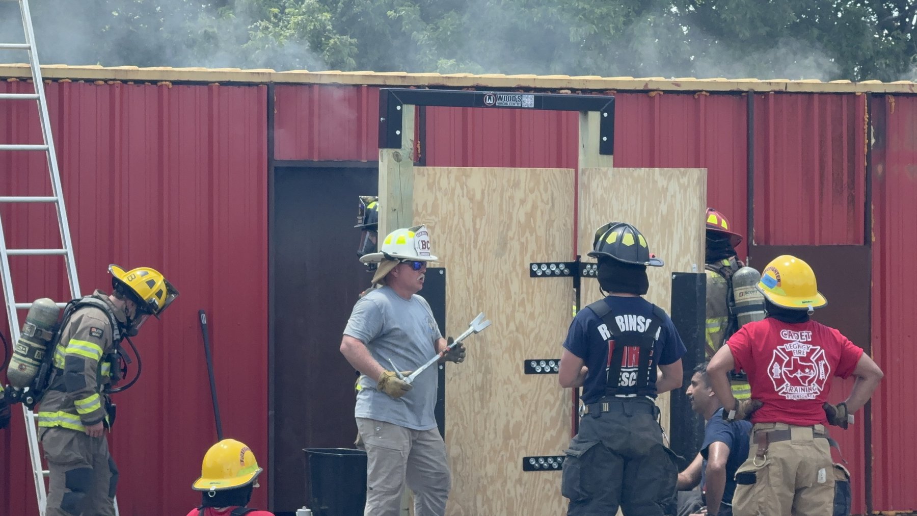 Firefighters and cadets train on a forcible-entry door prop at the academy